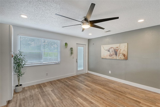 unfurnished room featuring ceiling fan, a textured ceiling, and light wood-type flooring