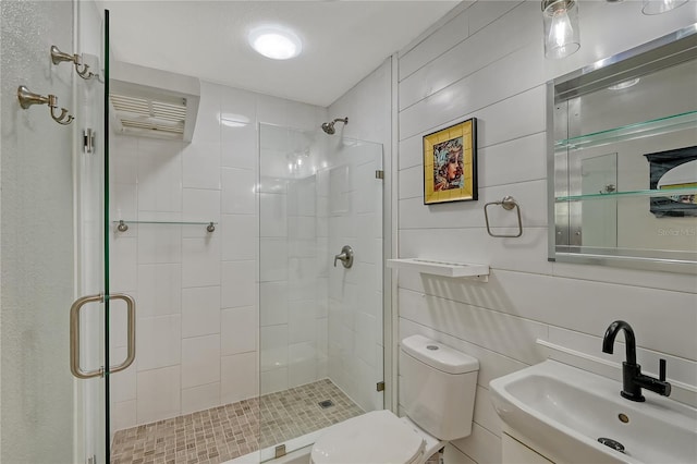 bathroom with sink, tile walls, toilet, and an enclosed shower