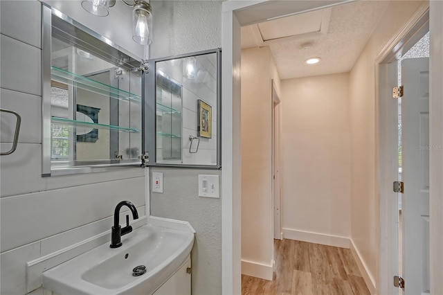 bathroom with wood-type flooring, a textured ceiling, and sink