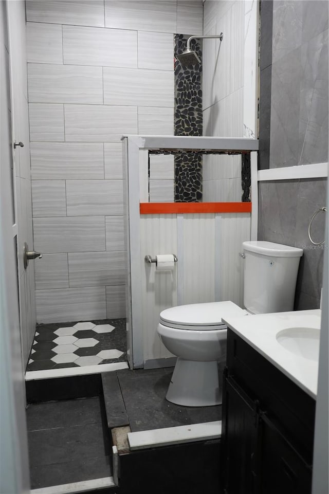 bathroom featuring walk in shower, vanity, toilet, and tile patterned floors