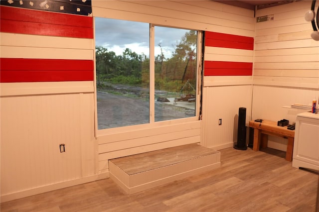 interior space featuring wood-type flooring and wooden walls