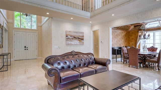 living room featuring a high ceiling, light tile flooring, crown molding, and an inviting chandelier