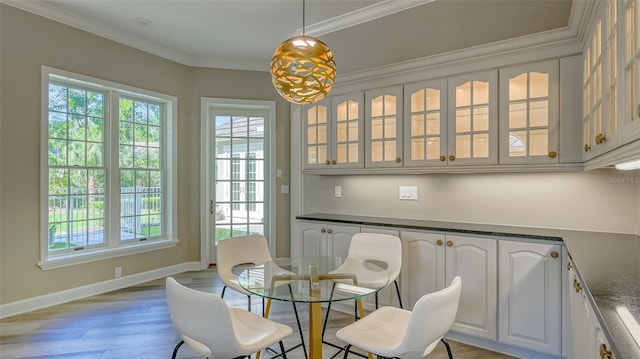 dining space featuring plenty of natural light, hardwood / wood-style floors, and ornamental molding