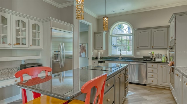 kitchen featuring a center island, light wood-type flooring, gray cabinetry, stainless steel appliances, and pendant lighting