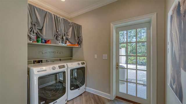 laundry room with light hardwood / wood-style floors, washer and dryer, and crown molding