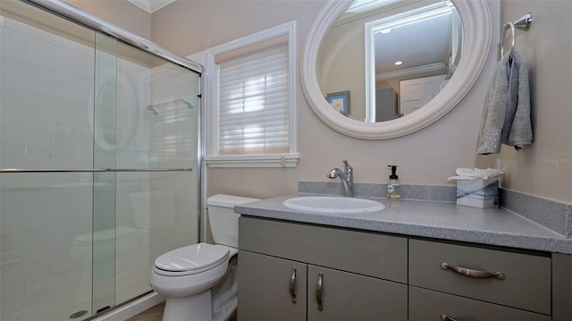 bathroom with crown molding, toilet, a shower with door, and large vanity