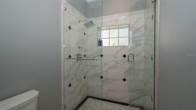 bathroom with a shower with shower door and toilet