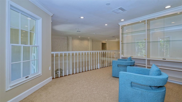 living area with crown molding and carpet