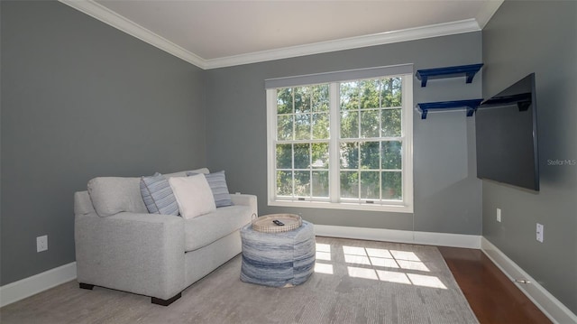 living area featuring plenty of natural light, crown molding, and hardwood / wood-style flooring