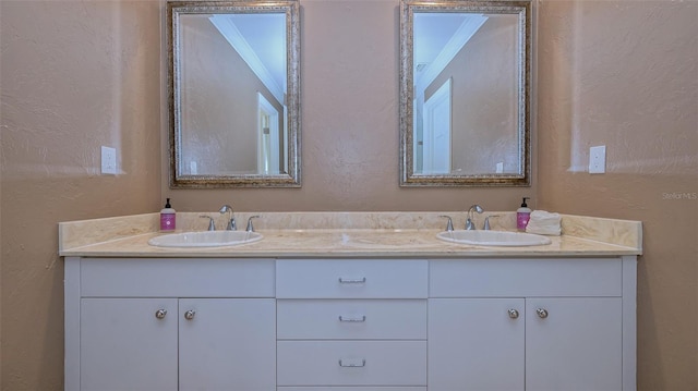 bathroom with ornamental molding and double vanity