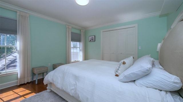 bedroom with a closet, multiple windows, crown molding, and hardwood / wood-style flooring