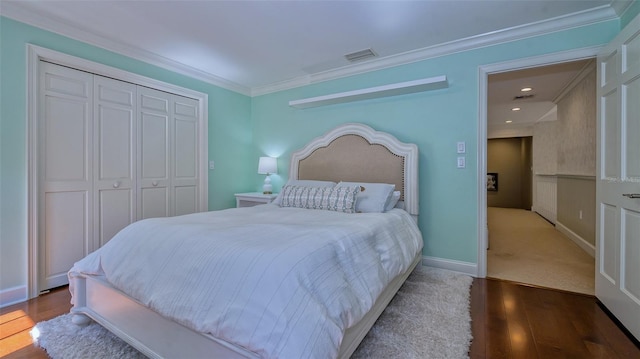 bedroom featuring hardwood / wood-style floors, a closet, and crown molding