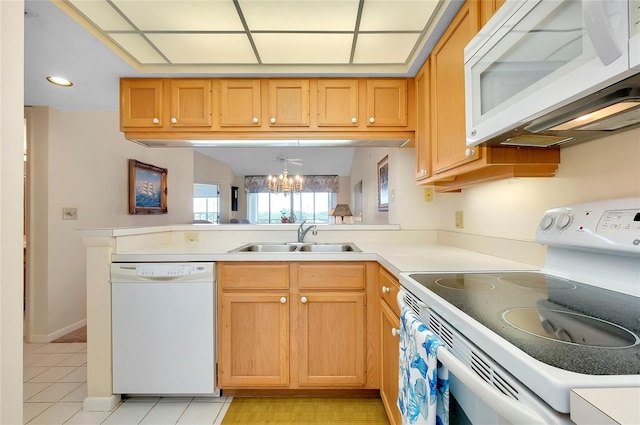 kitchen with light tile floors, sink, white appliances, a chandelier, and kitchen peninsula