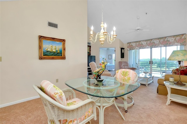 dining space with ceiling fan with notable chandelier, high vaulted ceiling, and carpet