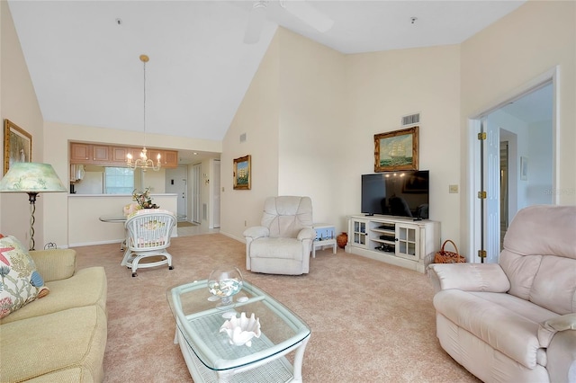 carpeted living room with ceiling fan with notable chandelier and high vaulted ceiling