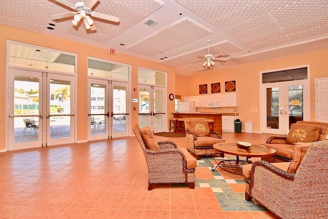 tiled living room with ceiling fan and french doors