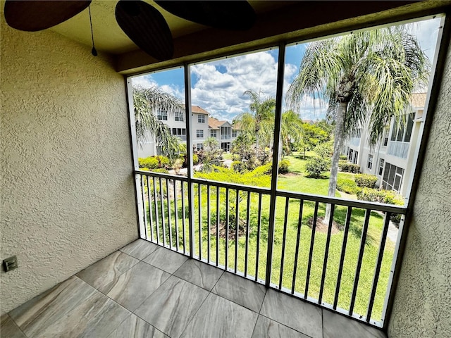 unfurnished sunroom featuring ceiling fan