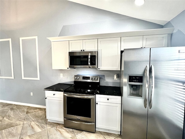 kitchen featuring appliances with stainless steel finishes, vaulted ceiling, and white cabinetry