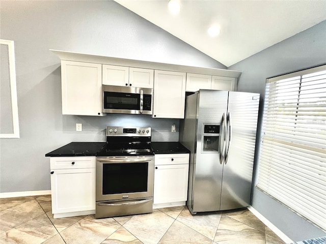 kitchen featuring white cabinets, appliances with stainless steel finishes, and vaulted ceiling