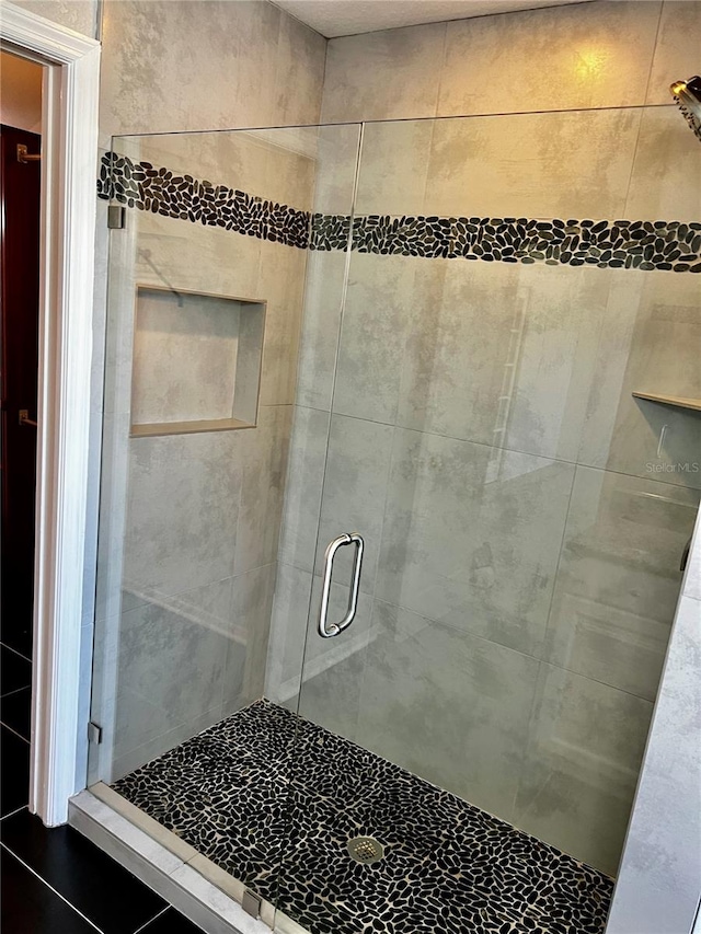 bathroom with tile patterned floors and walk in shower