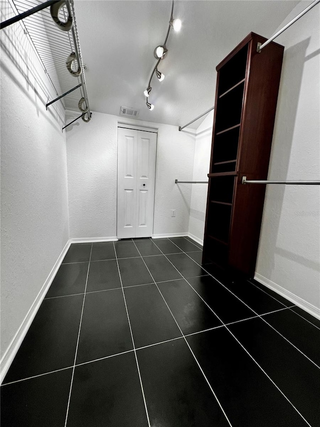 walk in closet featuring dark tile patterned floors