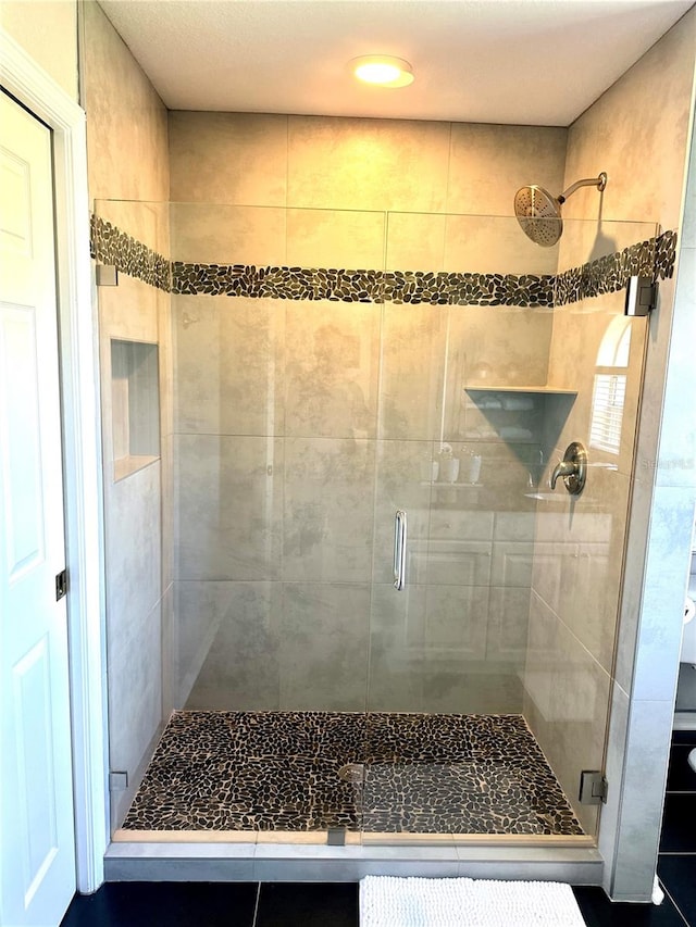 bathroom featuring a shower with door