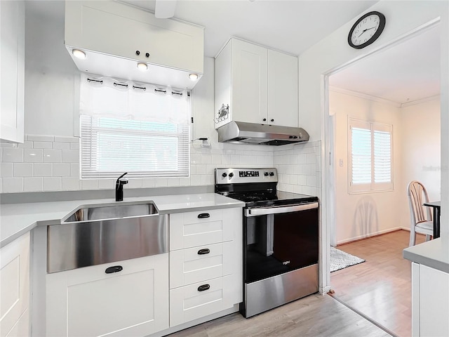 kitchen featuring sink, backsplash, light wood-type flooring, white cabinetry, and stainless steel electric range oven