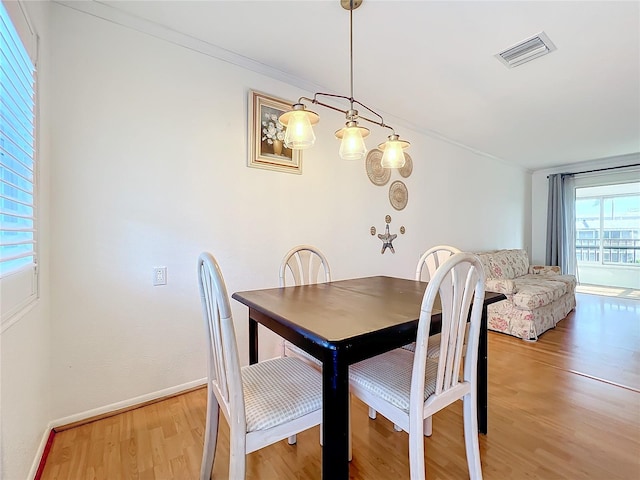 dining space featuring light hardwood / wood-style floors and ornamental molding