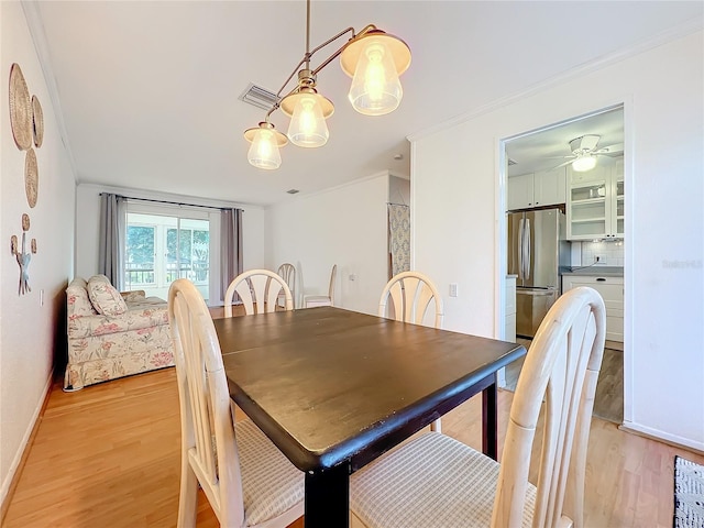 dining space with light hardwood / wood-style flooring, crown molding, and ceiling fan