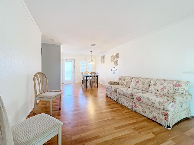 living room with wood-type flooring and ornamental molding