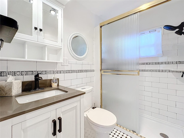 bathroom with vanity with extensive cabinet space, walk in shower, tile walls, tile flooring, and toilet