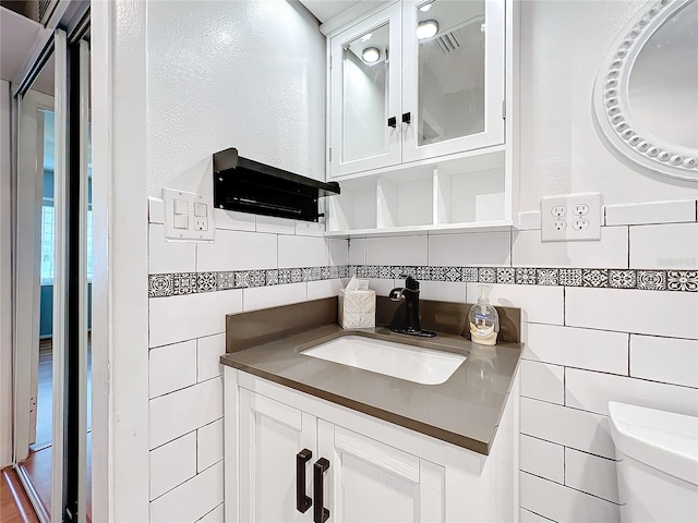 bathroom with hardwood / wood-style floors, vanity, toilet, and tile walls