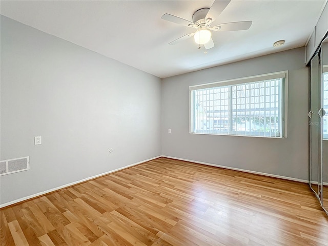 empty room with ceiling fan and light hardwood / wood-style floors