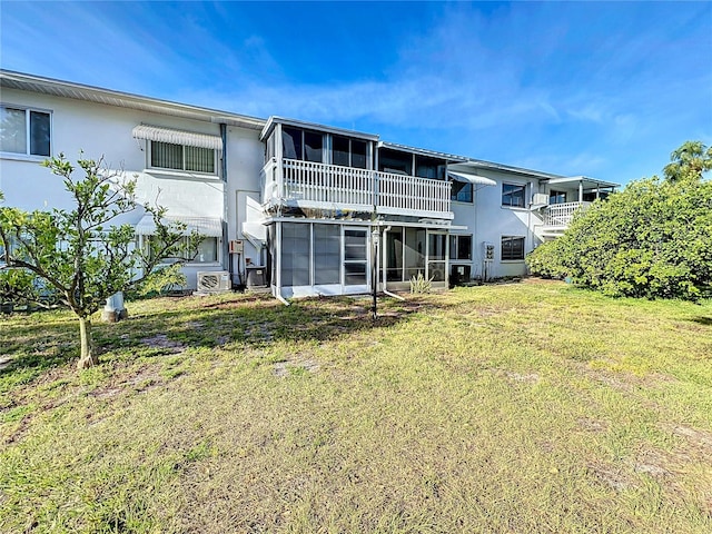 rear view of property with a balcony and a lawn