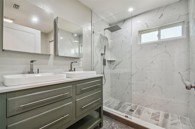 bathroom featuring tiled shower and vanity