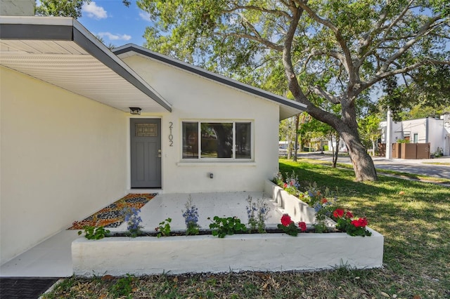 entrance to property featuring a lawn