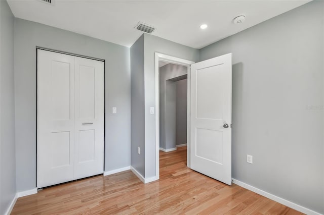 unfurnished bedroom featuring light wood-type flooring and a closet