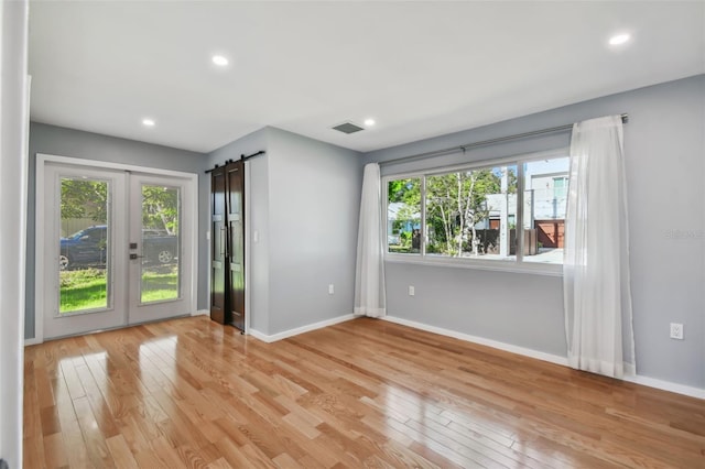 unfurnished room with light hardwood / wood-style floors and a healthy amount of sunlight