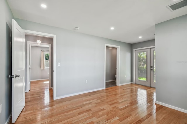 empty room with french doors and light wood-type flooring