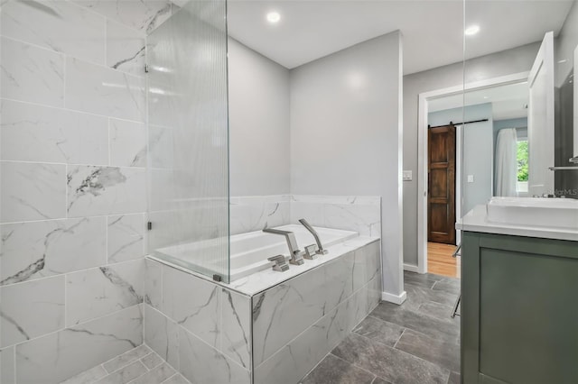 bathroom featuring vanity and independent shower and bath