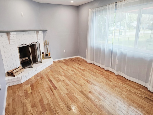 unfurnished living room featuring a fireplace and light hardwood / wood-style flooring