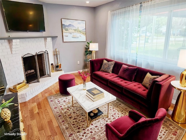 living room featuring hardwood / wood-style flooring and a brick fireplace