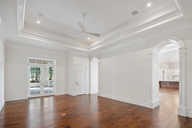 unfurnished room with french doors, ceiling fan, dark hardwood / wood-style floors, and a raised ceiling