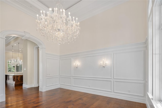 interior space with ornamental molding, dark wood-type flooring, a towering ceiling, and a notable chandelier