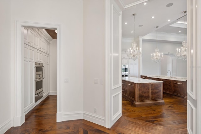 bathroom with ornamental molding, a notable chandelier, vanity, and hardwood / wood-style floors