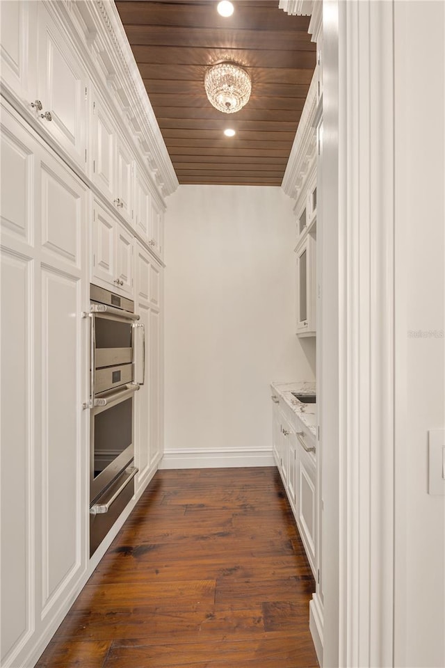 kitchen with dark wood-type flooring, white cabinetry, and wood ceiling