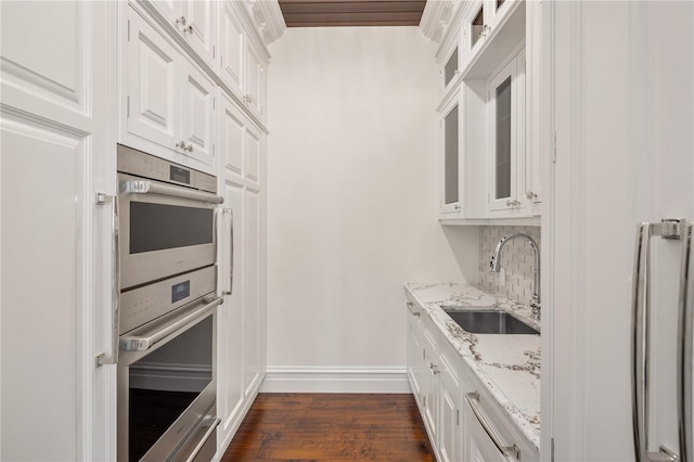 kitchen featuring dark hardwood / wood-style flooring, white cabinetry, stainless steel appliances, sink, and tasteful backsplash