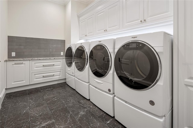 washroom with cabinets and washer and clothes dryer