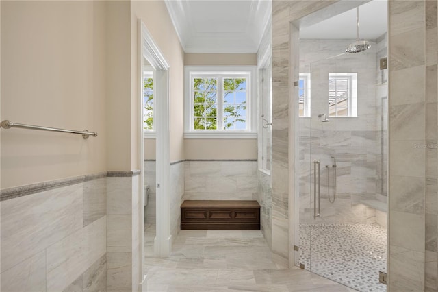 bathroom featuring ornamental molding, a shower with shower door, tile floors, and tile walls