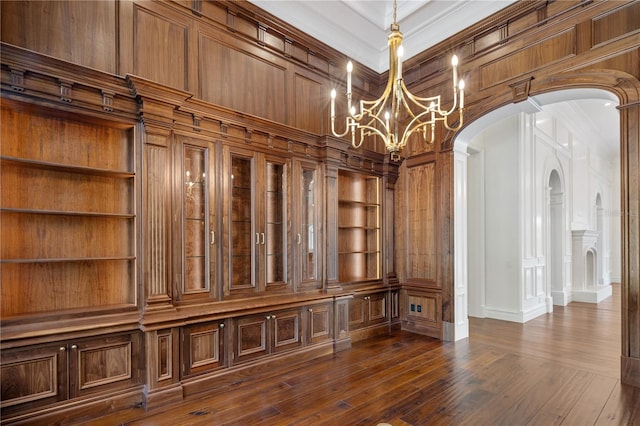 interior space featuring hardwood / wood-style flooring, crown molding, built in shelves, and a chandelier